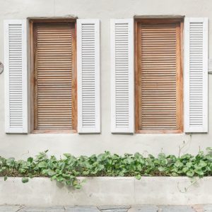 window with shutters and men and women written on wall