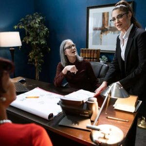 lawyer and judge speak to client while looking over paperwork