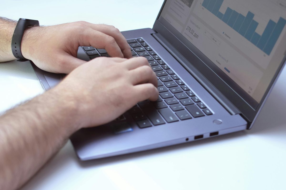 clost up of man's hands typing on a laptop computer