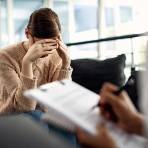 woman with her hands on her head in a therapist office