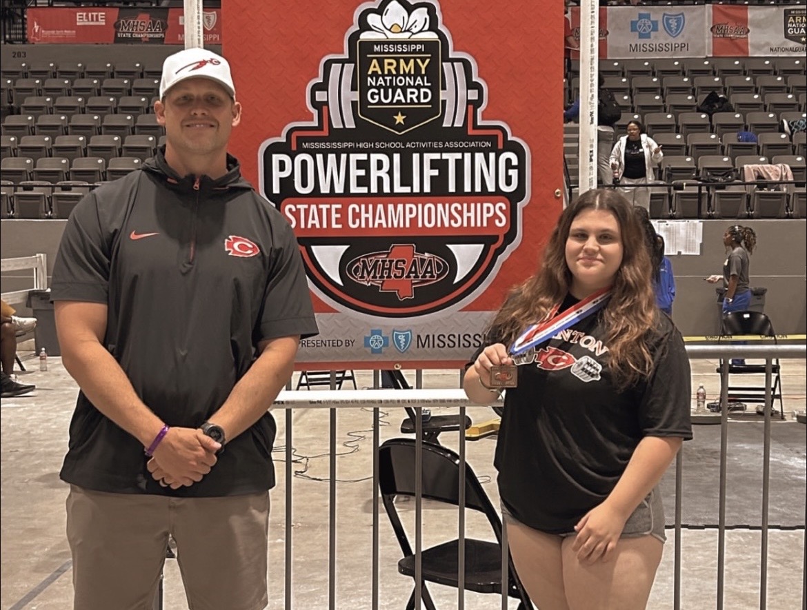 Clinton High School’s head girls’ powerlifting coach Patrick Ezell and Clinton senior Allison Herron celebrated her record-setting performance on March 28 at the MHSAA Class 7A State Meet at the Mississippi Coliseum in Jackson.