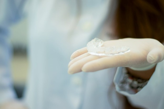 dentist holding clear aligners
