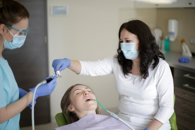 woman getting teeth cleaned at dentist office