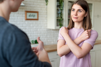man and woman talking with woman's arms crossed