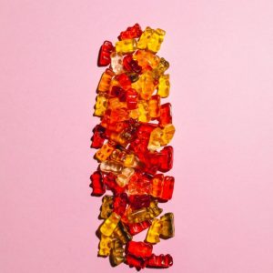colorful gummy bears on pink surface
