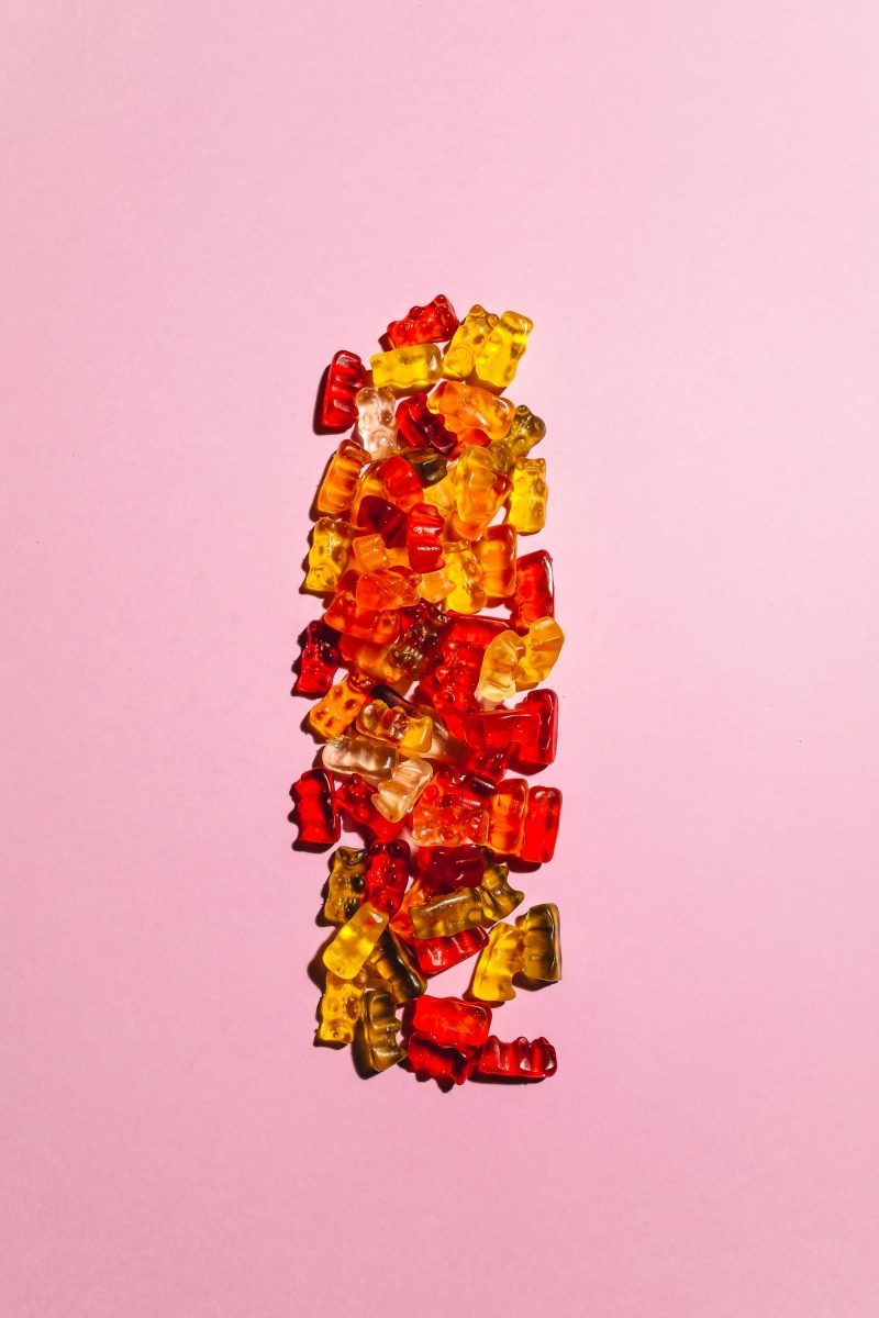 colorful gummy bears on pink surface