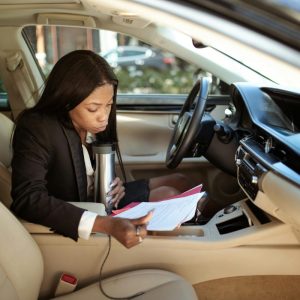 woman reading papers while sitting in a car
