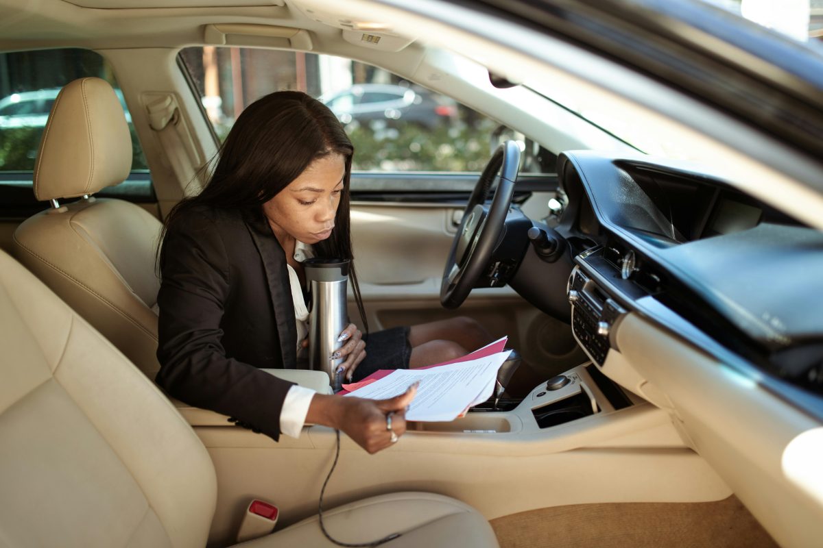 woman reading papers while sitting in a car