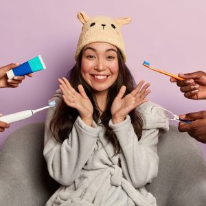 Portrait of young and beautiful woman smiling with toothbrush and toothpaste being handed over