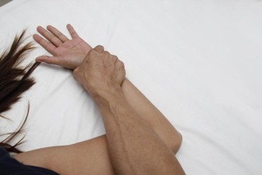 man holding arms of woman on the bed