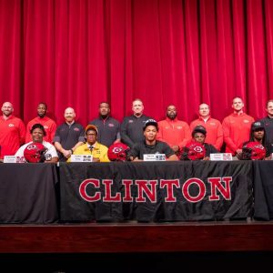 Pictured (l to r) in the front row are current Clinton High School seniors who recently signed to play football at the next level: Miles Bass (SMCC), Christian Cavett (MDCC), Jaiden King (MGCCC), Davon Merchant (JSU), Ashton Nichols (MDCC), Donovan Shaifer (ECCC) and Braylen Spann (HCC). Clinton Arrows coaching staff is pictured behind the players.