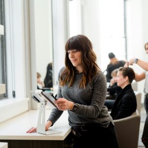 woman at ipad in barber shop