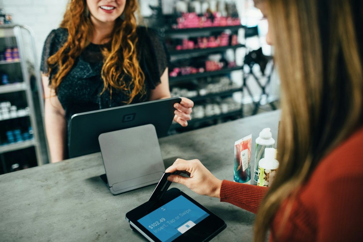 woman making a payment at point of sale system in a store