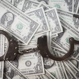 closeup of metal handcuffs laying on money