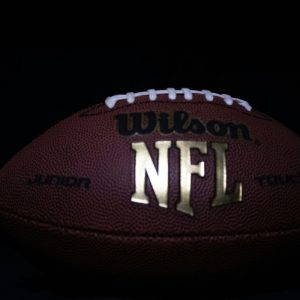 a close up of a nfl football on black background