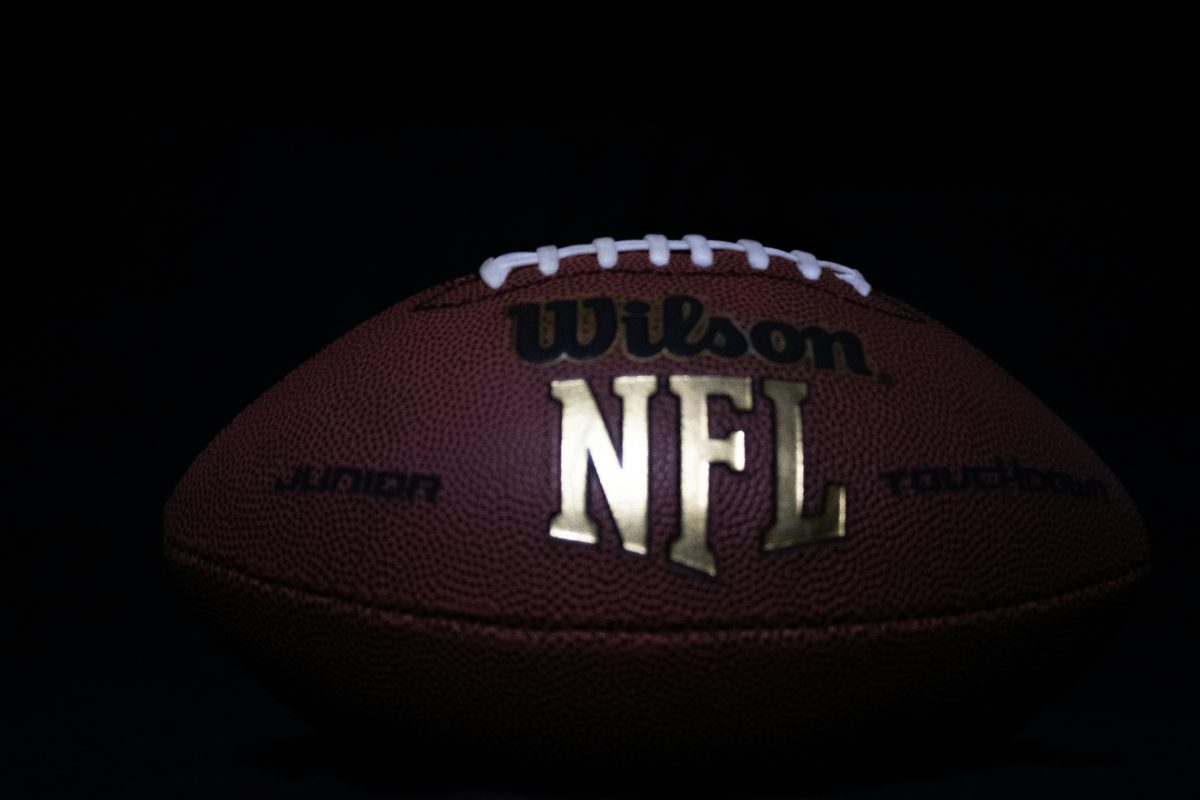a close up of a nfl football on black background