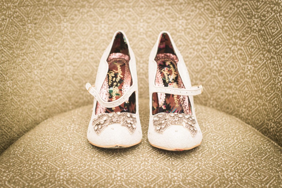 white diamond studded shoes sitting on beige couch