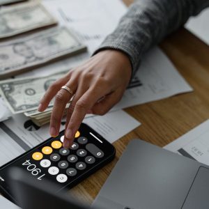 woman with calculator and money with papers
