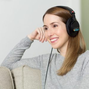 woman wearing headphones while sitting on a couch