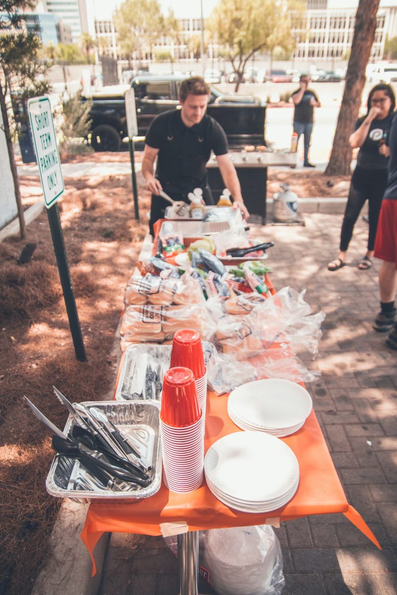 people preparing food at a table outside