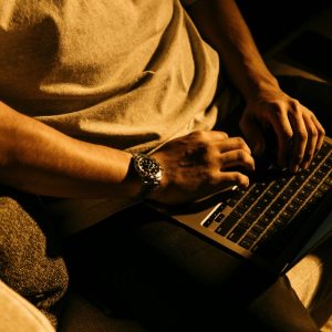 man sitting on a couch using a laptop computer