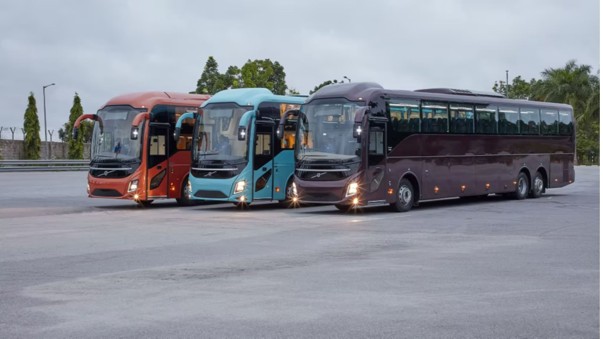 row of charter buses sitting in a parking lot