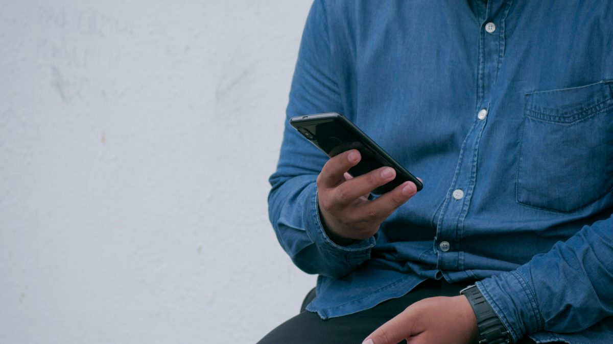 person in blue denim jacket holding phone