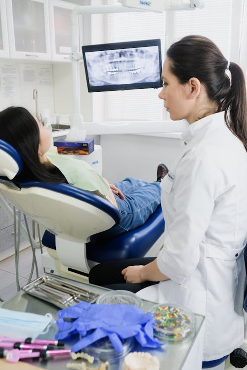 woman in dental chair with dentist looking at xray