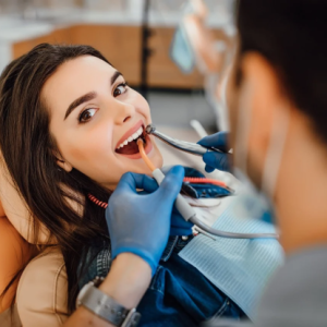 woman looking at camera while sitting in dentsit chair getting dental procedure