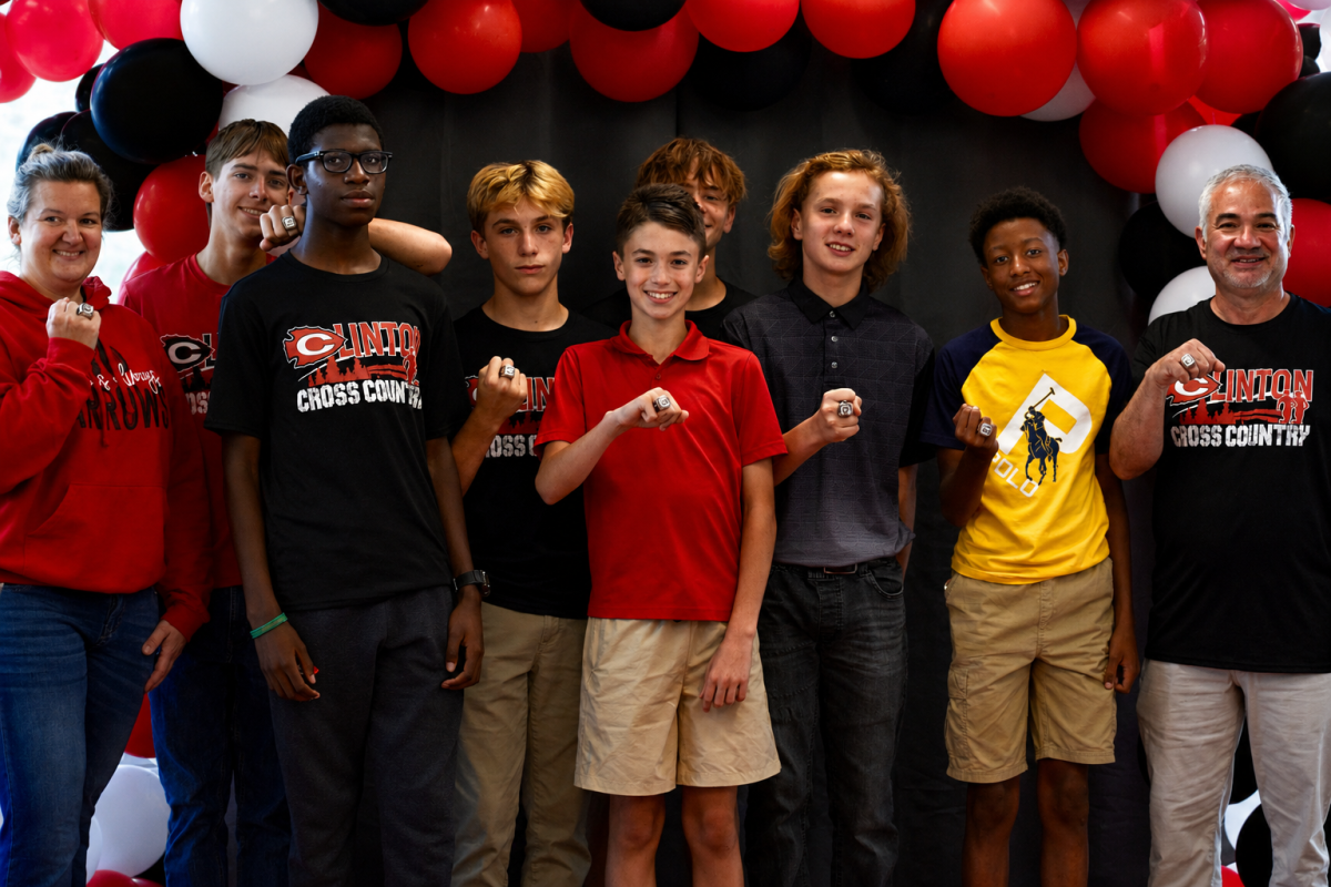 Pictured (l to r) are runners and coaches of the CJHS boys cross country team posing with their state championship rings during a ring ceremony held recently at Clinton High School.