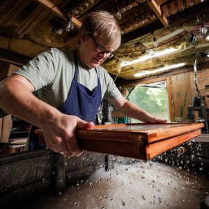 Utah artist Rob Buchert allows a freshly pulled sheet of handmade paper to drain at the vat, one step in recreating the 18th-century papermaking process used for the original 1776 Declaration of Independence. June 11, 2026.