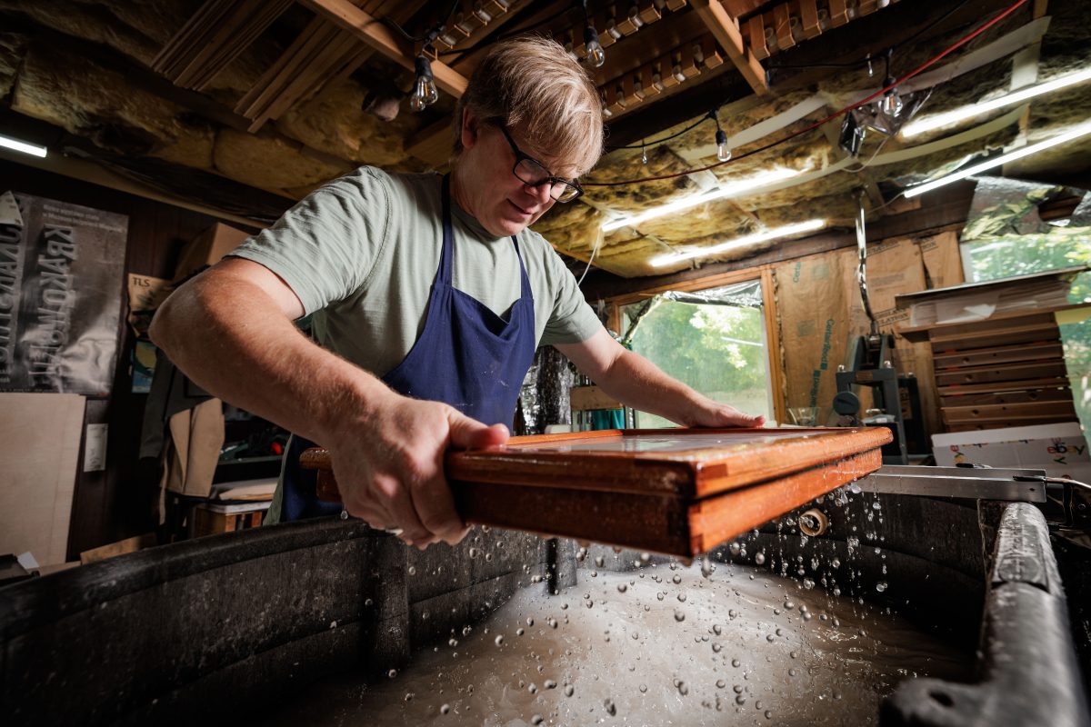 Utah artist Rob Buchert allows a freshly pulled sheet of handmade paper to drain at the vat, one stepin recreating the 18th-century papermaking process used for the original 1776 Declaration of Independence. June 11, 2026.