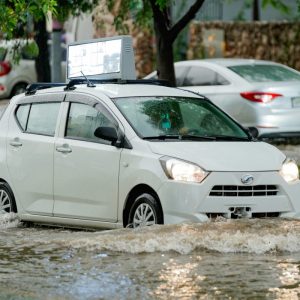 white car driving through the flooded street