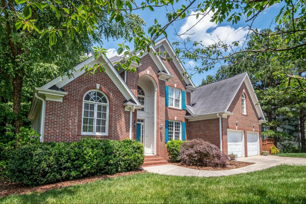 brick house with trees and green grass