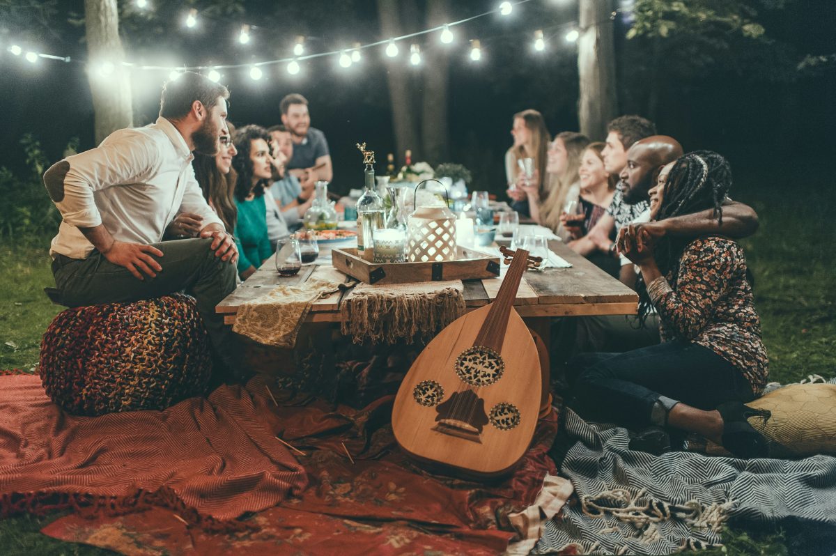 people sitting in chairs in front of table with candles