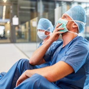 two medical professionals sitting on the floor of the hospital
