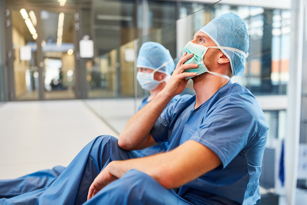 two medical professionals sitting on the floor of the hospital