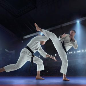 two men in white karate uniforms fighting
