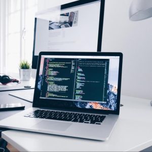 laptop sitting on a home desk showing code