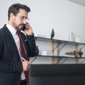man in black suit and jacket talking on phone