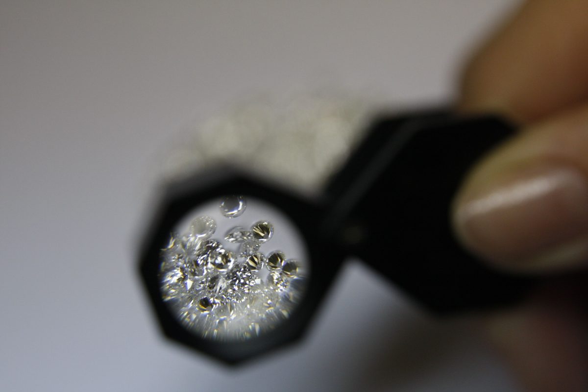 crop jeweler with loupe and gemstones