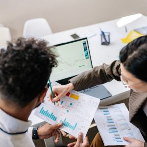 two colleagues looking over graphs on paper