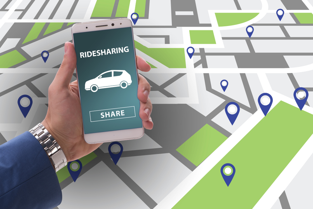 man holding a phone with rideshare above a map