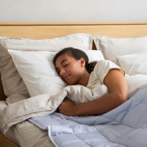 young girl sleeping in a bed with white sheets