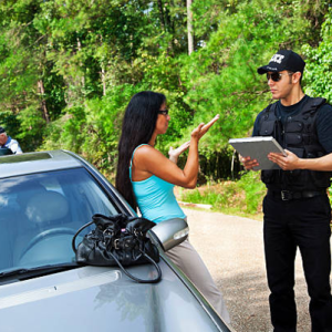 Crime: Policeman makes traffic stop. Woman explaining. Officer background.