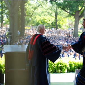 Chancellor Glenn Boyce (left) invites Ole Miss alumnus Brett Young to the Grove stage during the University of Mississippi's 173rd Commencement on May 9. Young, a country music singer and former Ole Miss baseball pitcher, advised graduates to follow their dreams and be unafraid to pivot. Photo by Kevin Bain/Ole Miss Digital Imaging Services