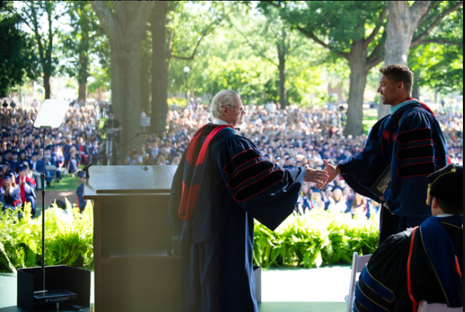 Chancellor Glenn Boyce (left) invites Ole Miss alumnus Brett Young to the Grove stage during the University of Mississippi's 173rd Commencement on May 9. Young, a country music singer and former Ole Miss baseball pitcher, advised graduates to follow their dreams and be unafraid to pivot. Photo by Kevin Bain/Ole Miss Digital Imaging Services