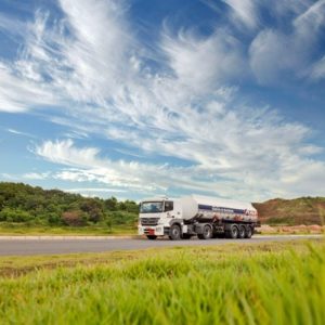 big rig truck on open road with blue skys and hills