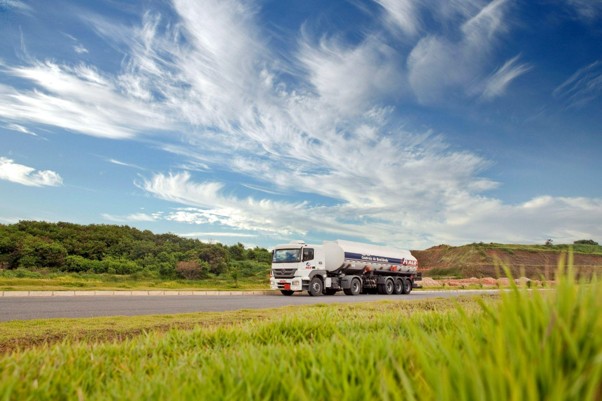 big rig truck on open road with blue skys and hills