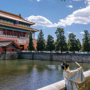 chinese women take a picture near chinese building on water